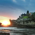 A stunning view of Tanah Lot Temple, perched on a rocky island with the ocean surrounding it, a symbol of Bali's cultural heritage.
