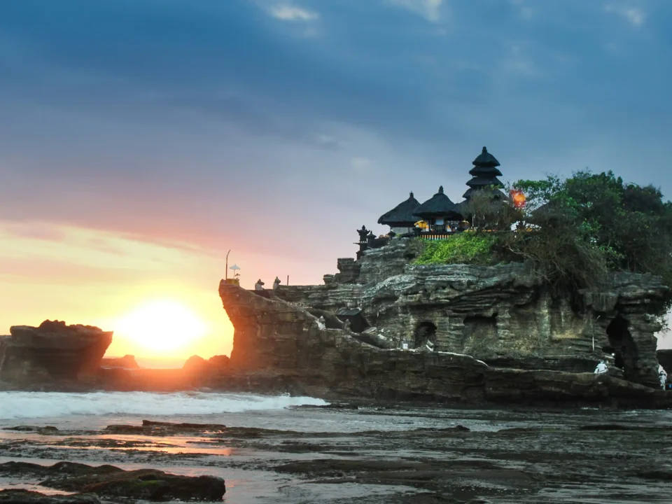 A stunning view of Tanah Lot Temple, perched on a rocky island with the ocean surrounding it, a symbol of Bali's cultural heritage.