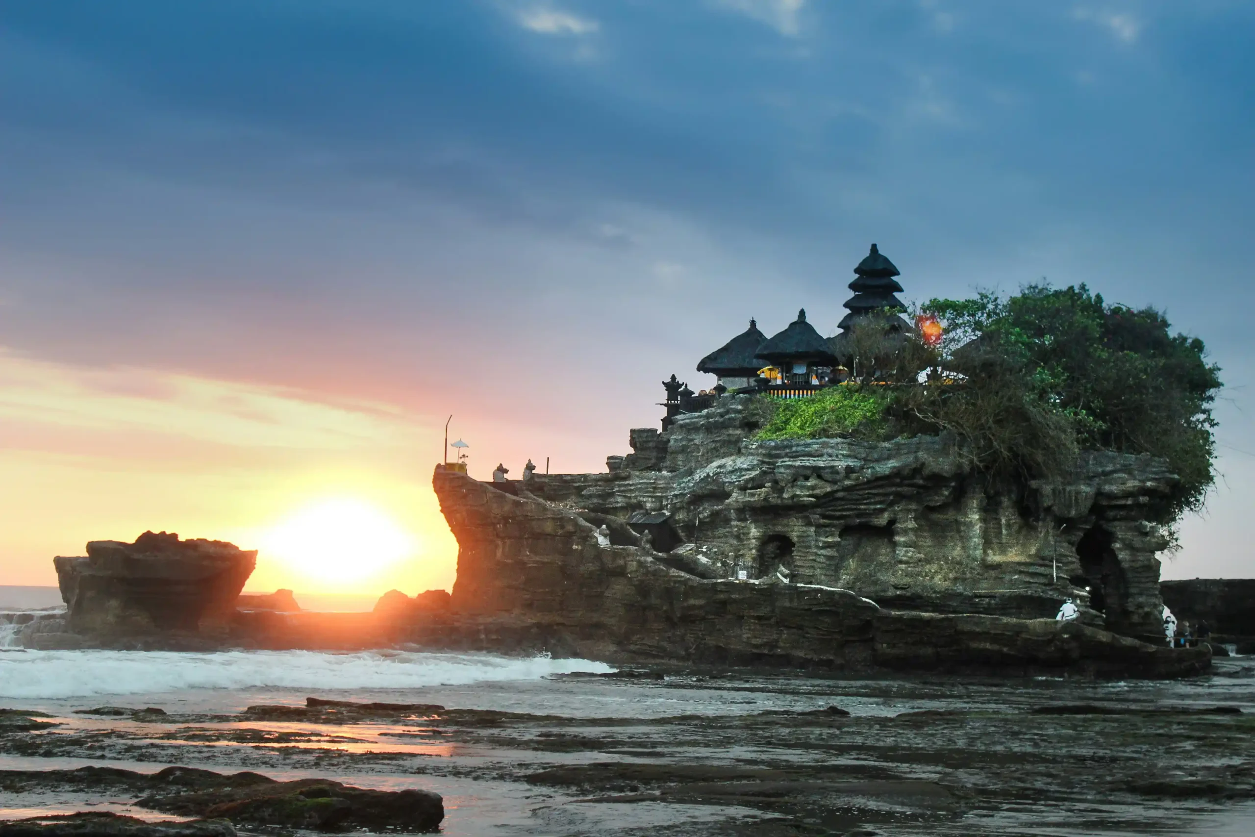 A stunning view of Tanah Lot Temple, perched on a rocky island with the ocean surrounding it, a symbol of Bali's cultural heritage.