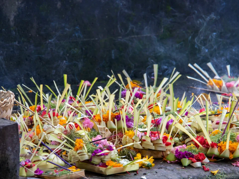 A Canang Sari offering in Bali, made of palm leaf, flowers, and incense, honoring the gods.
